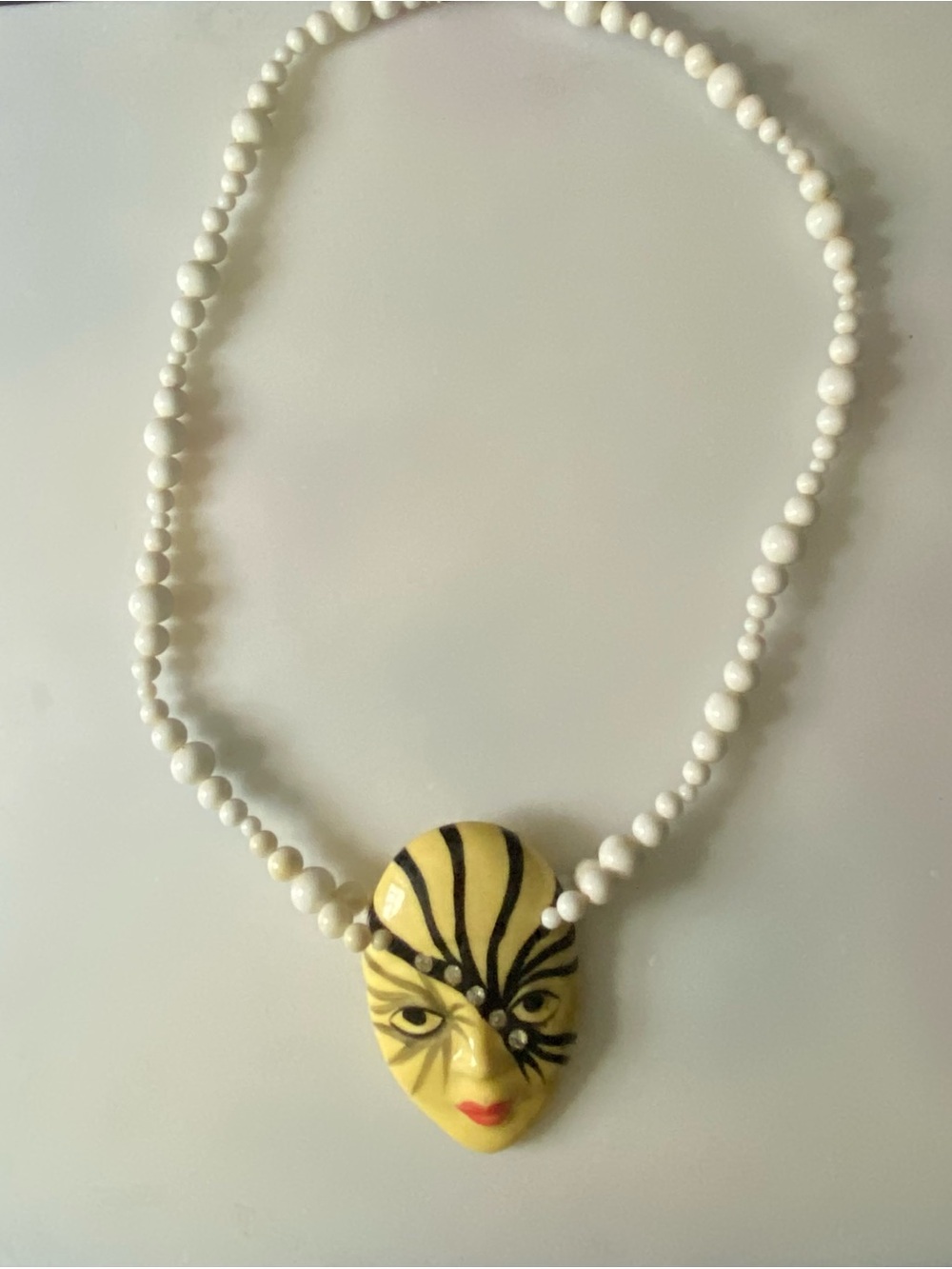 White Beaded Necklace with Yellow Mask Pendant